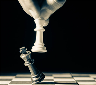 Picture of two chess pieces, one white piece knocking over a black piece